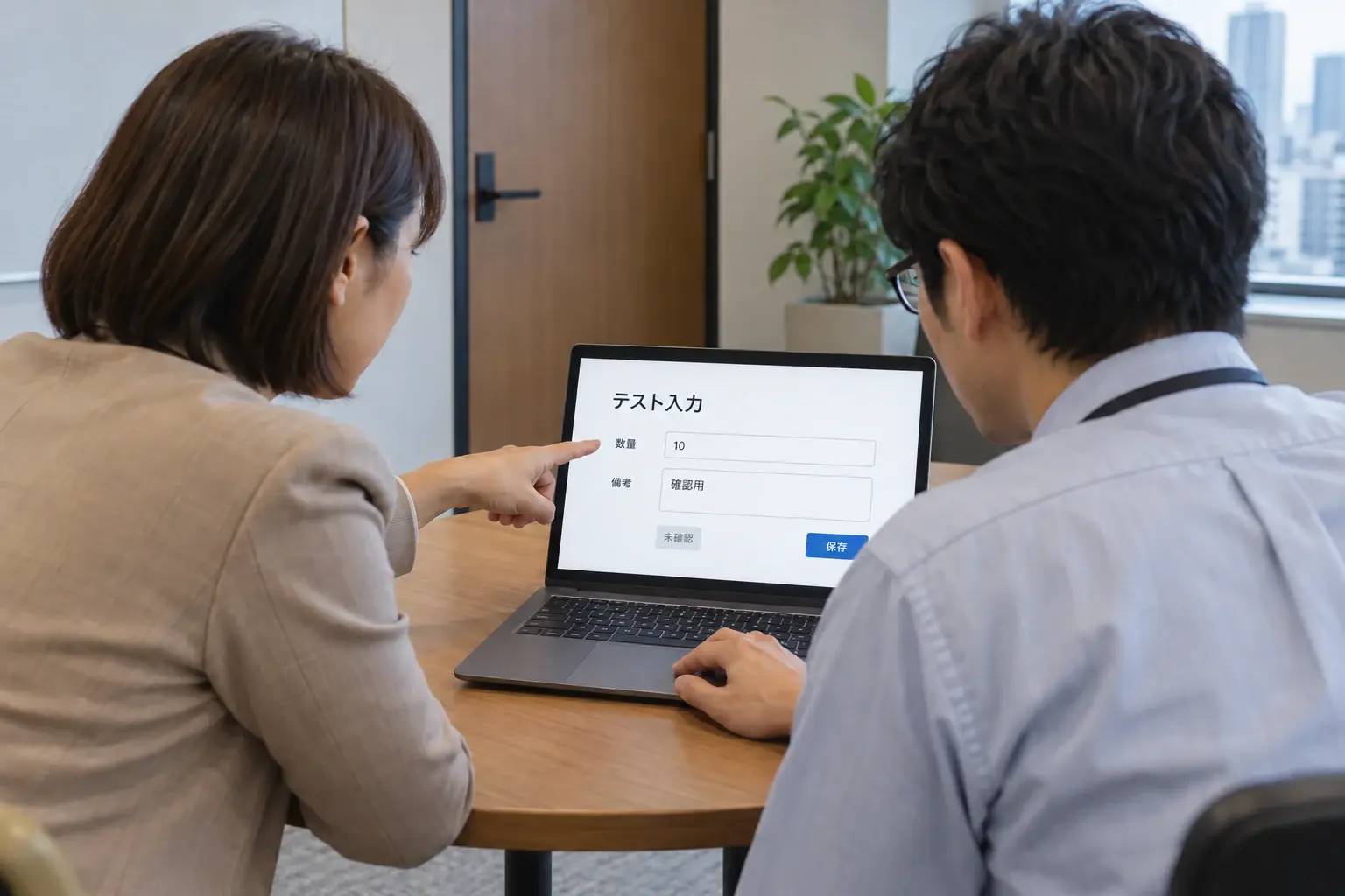 利用者側に向いたノートパソコンの業務入力画面を、業務責任者と開発担当者が確認するイメージ